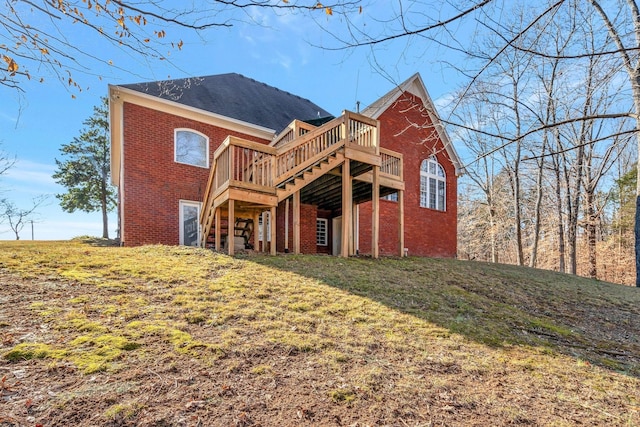 rear view of property with a wooden deck and a yard