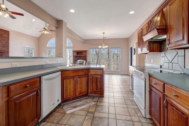 kitchen featuring pendant lighting, sink, white appliances, lofted ceiling, and tasteful backsplash