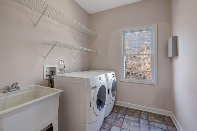 laundry area with separate washer and dryer and sink