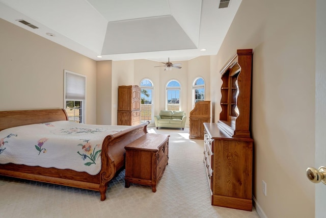 carpeted bedroom with a tray ceiling and ceiling fan