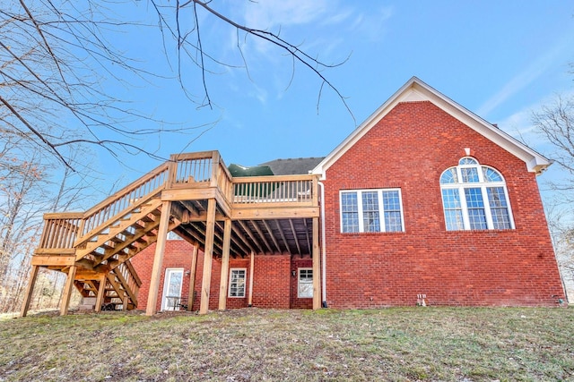 back of property with a deck and a lawn