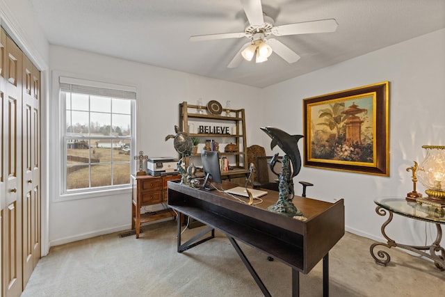 carpeted office space featuring ceiling fan