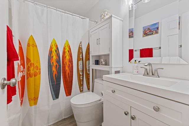 bathroom featuring vanity, toilet, and curtained shower