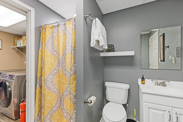 bathroom featuring vanity, washer / dryer, toilet, and a shower with shower curtain