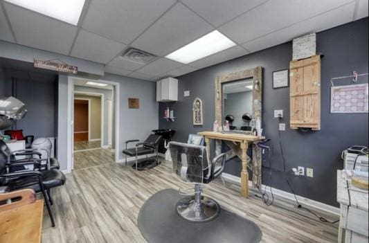 interior space featuring a drop ceiling and hardwood / wood-style flooring