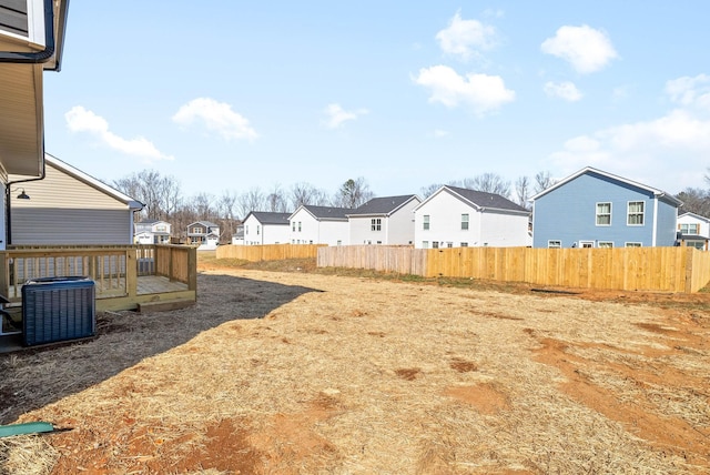 view of yard with central AC and a deck