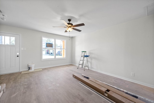 workout room featuring ceiling fan and light hardwood / wood-style flooring