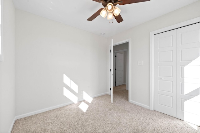 unfurnished bedroom with light colored carpet, ceiling fan, and a closet