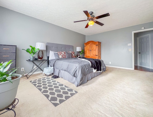 carpeted bedroom with ceiling fan and a textured ceiling