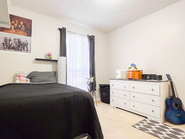 bedroom with light colored carpet and a textured ceiling