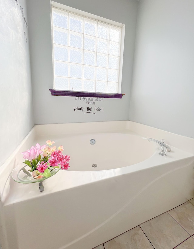 bathroom with plenty of natural light, a bathing tub, and tile patterned flooring