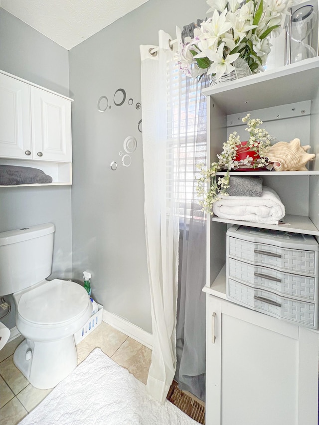 bathroom featuring toilet and tile patterned flooring