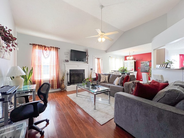 living room featuring lofted ceiling, ceiling fan with notable chandelier, and dark hardwood / wood-style floors