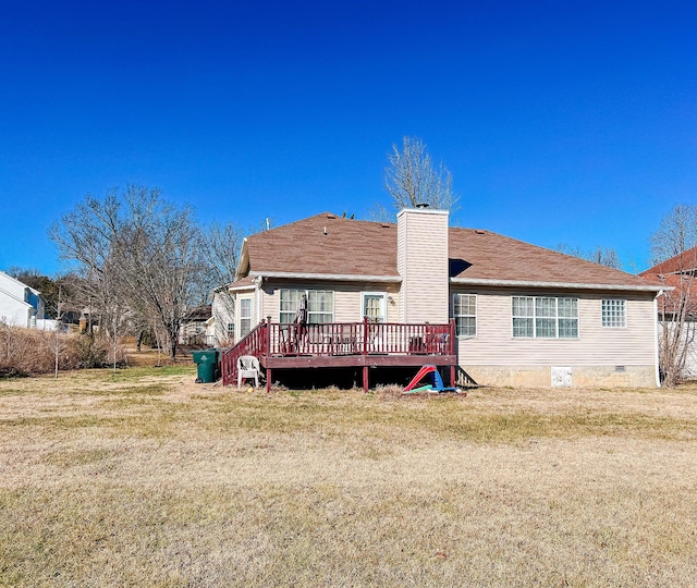 back of property with a wooden deck and a yard