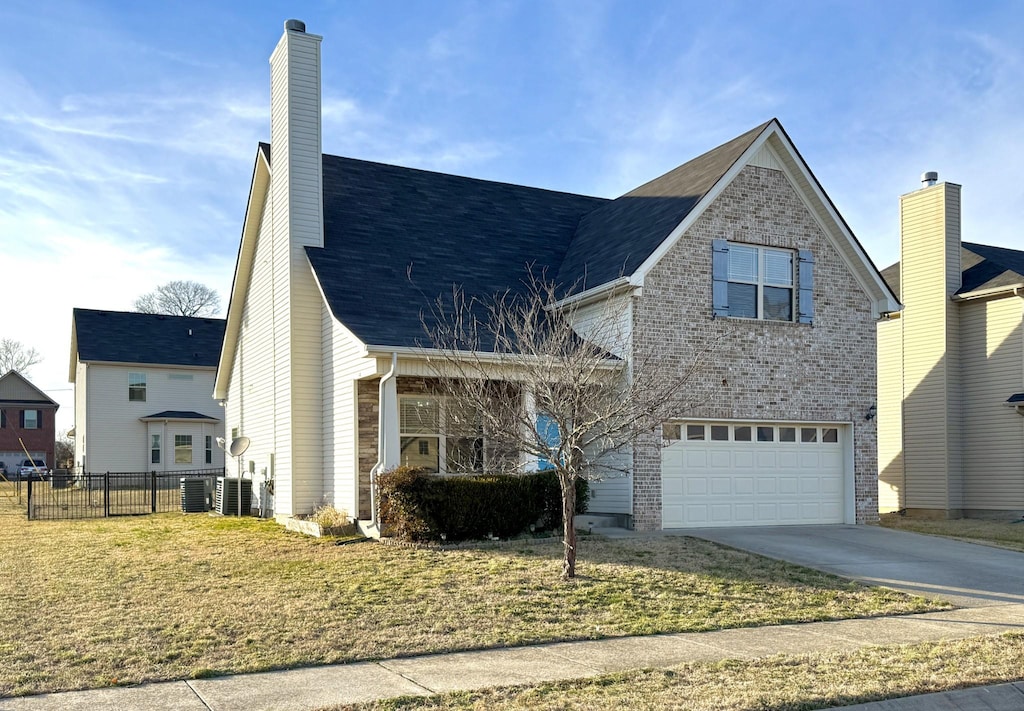 view of front of home with a garage, central AC unit, and a front yard