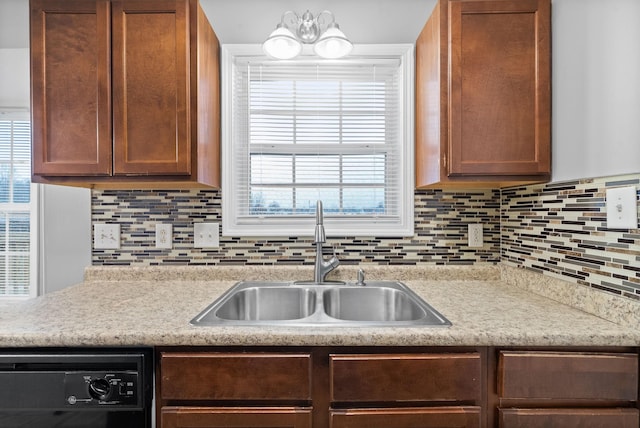 kitchen with black dishwasher, sink, and backsplash