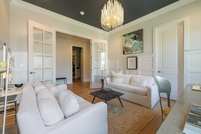 living room with a notable chandelier, crown molding, and light hardwood / wood-style flooring