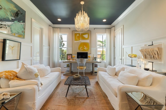 sitting room with an inviting chandelier, ornamental molding, hardwood / wood-style floors, and a wealth of natural light