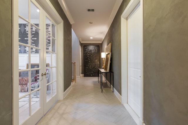 hall featuring french doors, crown molding, and light parquet floors