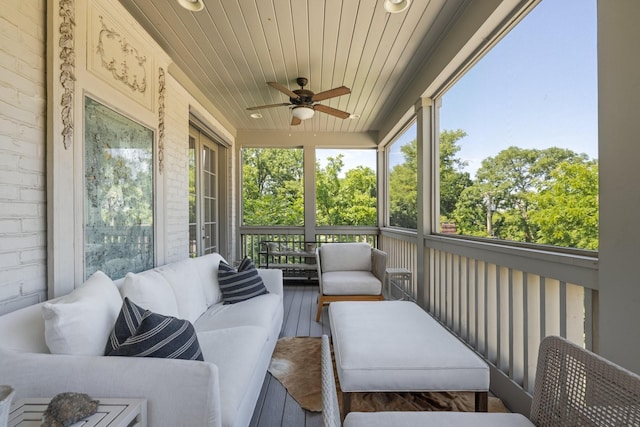 sunroom with ceiling fan and wooden ceiling