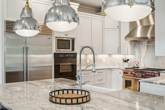 kitchen with white cabinetry, built in appliances, backsplash, and light stone counters