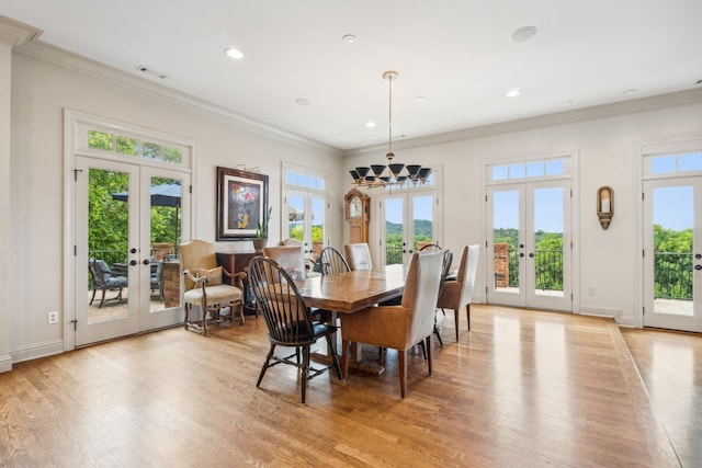 dining space with ornamental molding, a wealth of natural light, light hardwood / wood-style floors, and french doors