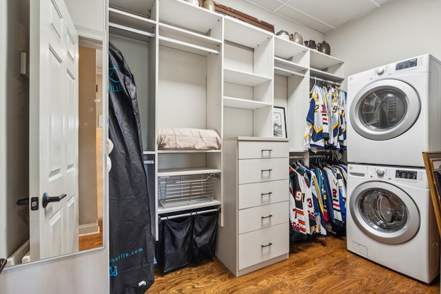 washroom with dark hardwood / wood-style floors and stacked washing maching and dryer