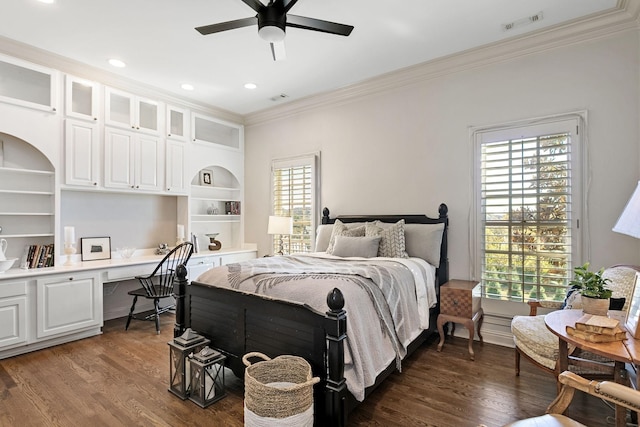 bedroom with ornamental molding, dark hardwood / wood-style floors, built in desk, and ceiling fan