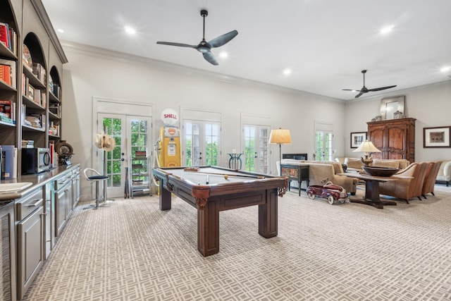 playroom with light carpet, a wealth of natural light, ornamental molding, and french doors