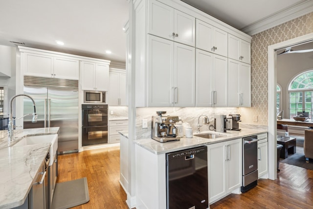 kitchen featuring sink, white cabinets, and black appliances