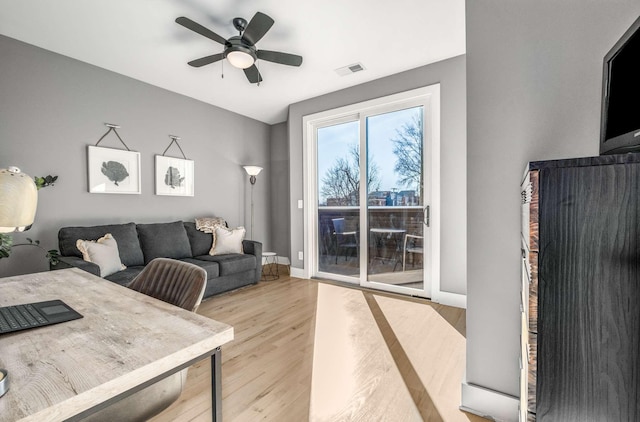 office space featuring baseboards, wood finished floors, visible vents, and a ceiling fan