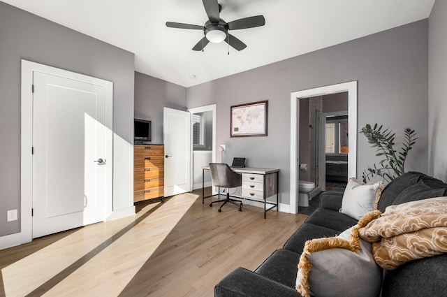 home office featuring light wood-style floors, ceiling fan, and baseboards