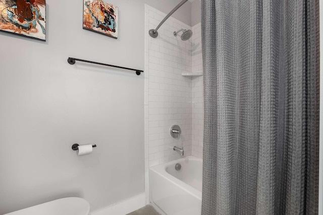 bathroom with toilet, baseboards, and shower / bath combo with shower curtain