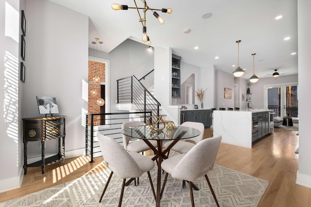 dining space featuring sink, a notable chandelier, and light hardwood / wood-style floors