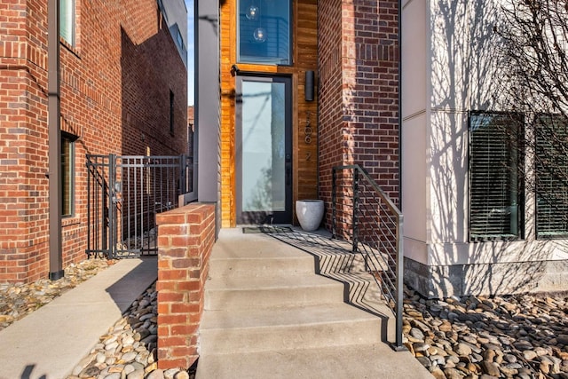 entrance to property featuring brick siding