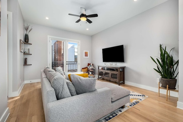 living area featuring light wood finished floors, ceiling fan, and baseboards