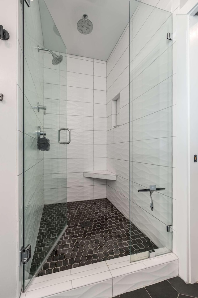 bathroom with a stall shower and tile patterned floors