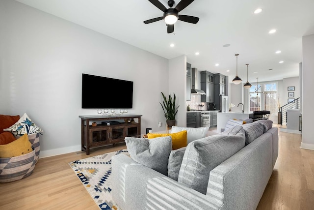 living room with a ceiling fan, recessed lighting, light wood-style flooring, and baseboards