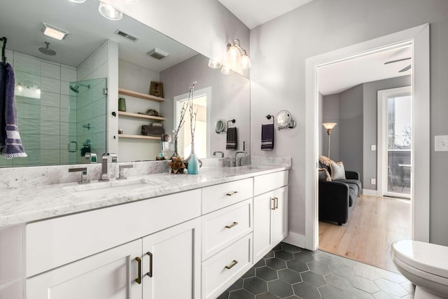 full bath with a sink, visible vents, a shower stall, tile patterned floors, and double vanity