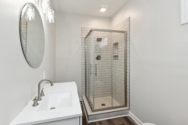 bathroom with vanity, hardwood / wood-style flooring, and a shower with shower door