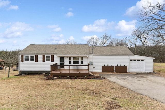 view of front of property with a garage, a deck, and a front lawn