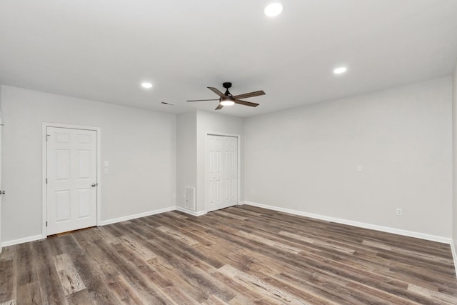 spare room featuring dark wood-type flooring and ceiling fan