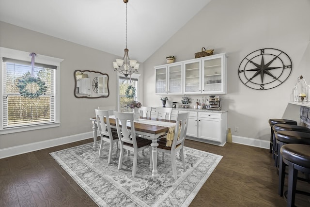 dining area featuring lofted ceiling, dark wood-type flooring, and a chandelier