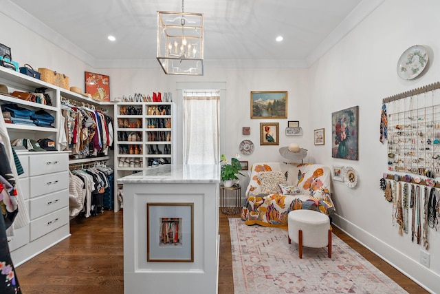 walk in closet with hardwood / wood-style flooring and an inviting chandelier