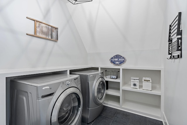 laundry room featuring dark tile patterned flooring and washer and clothes dryer