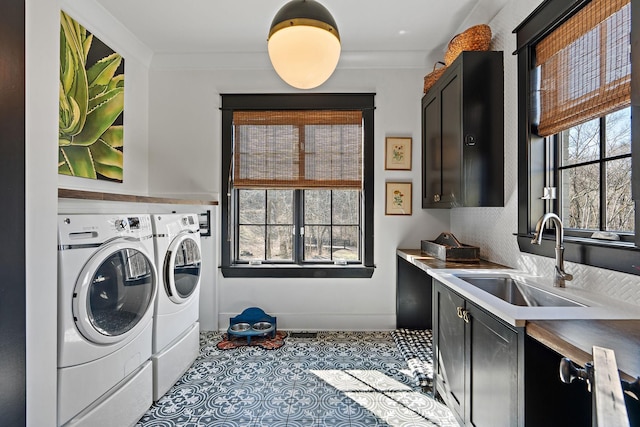 laundry room featuring cabinets, crown molding, separate washer and dryer, and sink