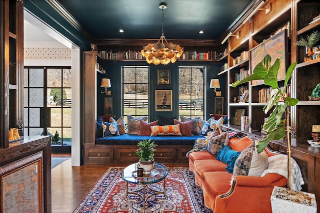 sitting room with crown molding, a chandelier, and hardwood / wood-style floors