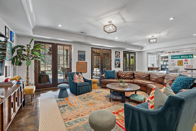 living room featuring a raised ceiling and french doors