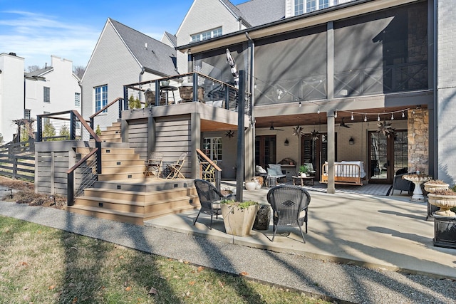 rear view of property featuring ceiling fan and a patio area