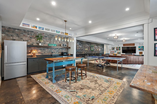 bar with pendant lighting, stainless steel fridge, and tasteful backsplash